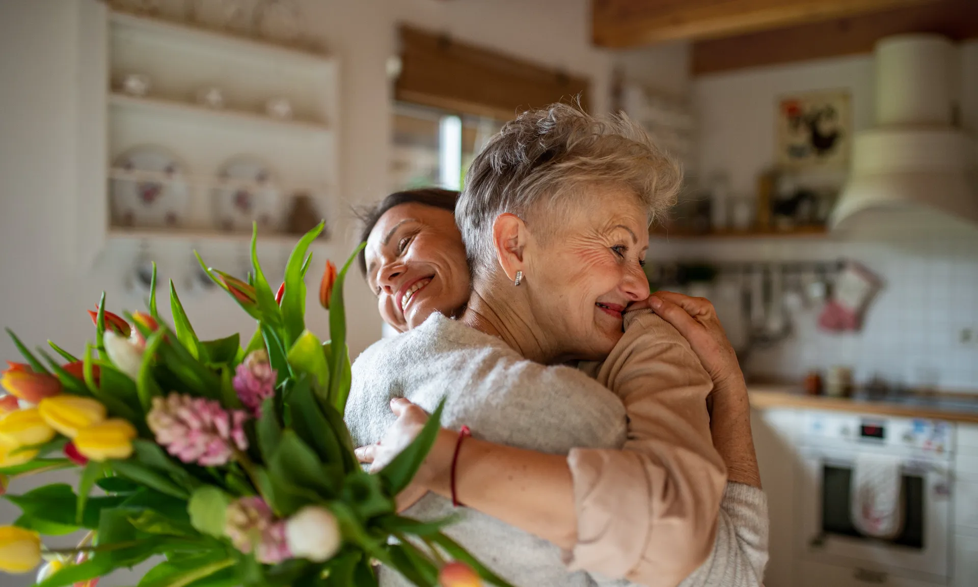 Happy senior mother hugging adult daughter