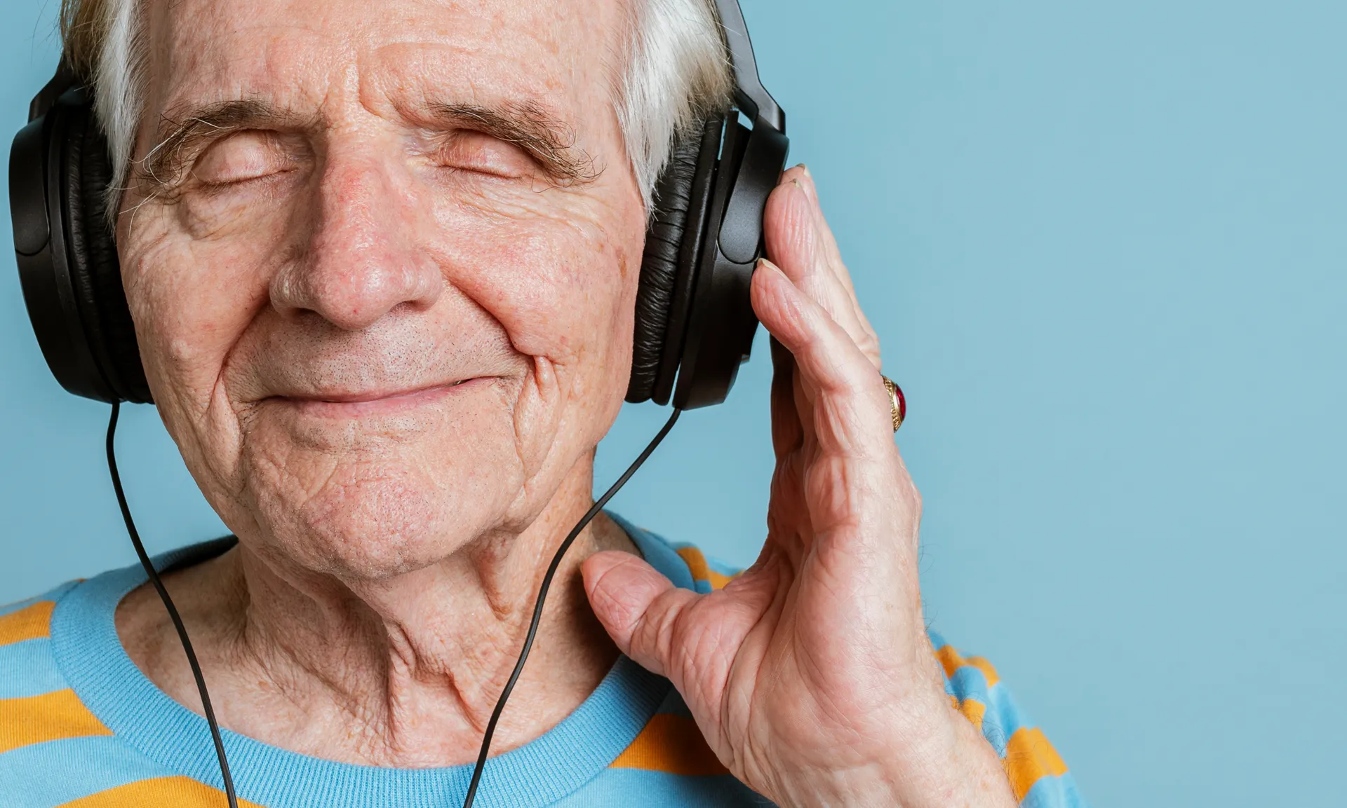 senior man listening to music with headphones